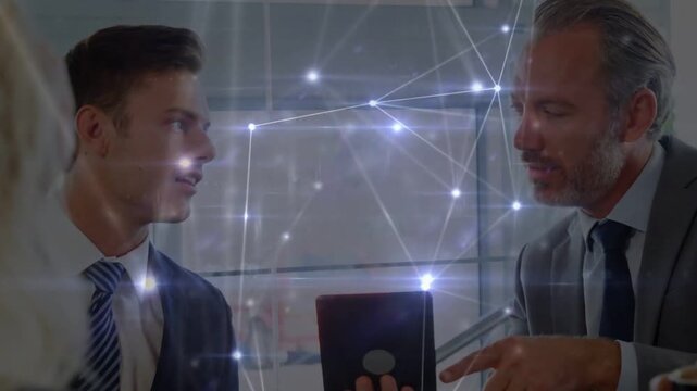 Senior exec pointing at tablet, starting lit tech network overlay for data review, junior listening