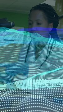 Vertical video: Seated woman looking as tech dotted-matrix wave sweeping across face, watching mic