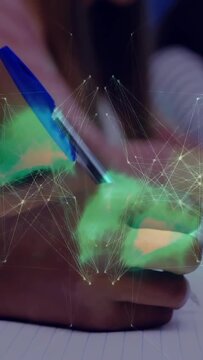 Vertical video: Right hand writing on paper with blue pen causing holo net around pen tip for study