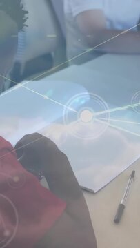 Vertical video: Boy in red shirt lowering pencil, peers marking sheets, overlay guiding education