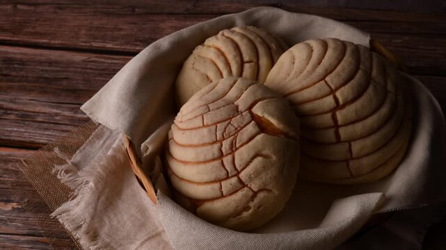 Low key video of sweet Mexican bread rolls with shell-like pattern, Mexican conchas