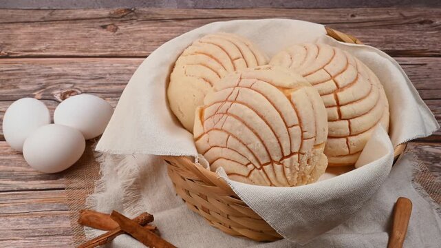Traditional Mexican sweet bread conchas in a wicker basket with eggs and cinnamon