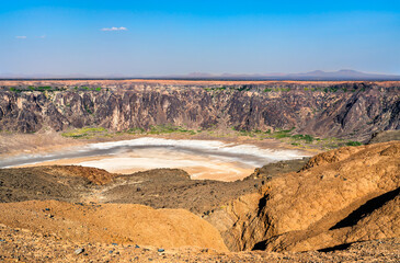 High angle panoramic view showing the white salt crust and steep walls of the Al Wahba volcanic crater located in the desert of Saudi Arabia.