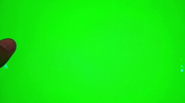 Asian man's hand scrolling, pausing, and double-tapping to like a post on a green screen tablet or smartphone. Aesthetic indoor room setting for social media, app interface, and digital technology.
