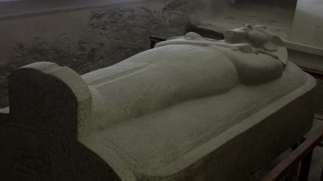Static shot of the massive red granite anthropoid sarcophagus of Pharaoh Merenptah inside tomb KV8 in the Valley of the Kings