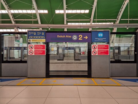 Bekasi, Indonesia - March 21, 2026: Platform screen doors at Cikunir 1 LRT Station, Bekasi, Indonesia. Modern urban transportation system with signage and safety warnings.