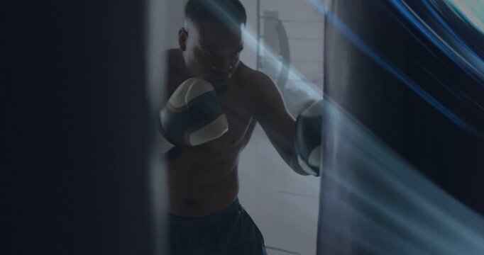 Boxer training on heavy bag in gym, curtain gap revealing start, blue streaks highlighting punches