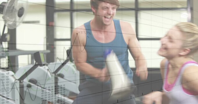 Man shouting through megaphone and initiating woman rowing set, showing ergometer fans for fitness