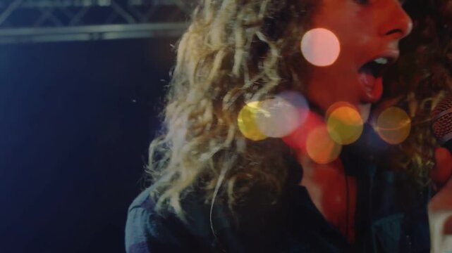 Vertical video: Lead singer gripping microphone, singing for live music, bokeh showing motion