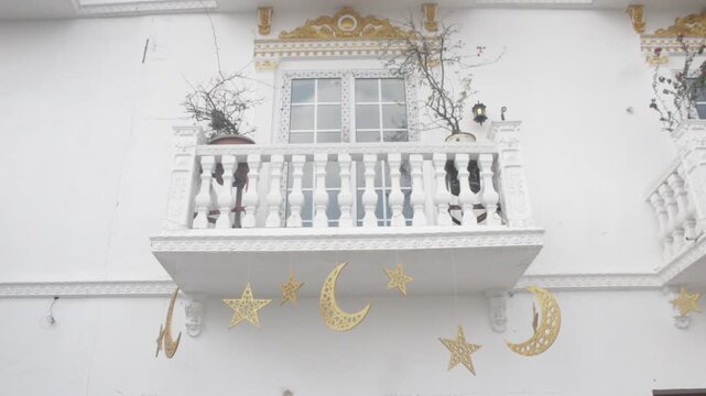 A balcony white painted showing stars and moon props signifying celebration of Eid and Ramadan