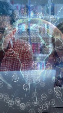 Vertical video: Group tapping phones leaning on laptop, starting holo globe across screens learning