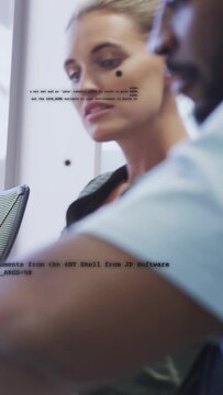 Vertical video: Woman dev speaking, causing code overlay while man dev typing, debugging tech