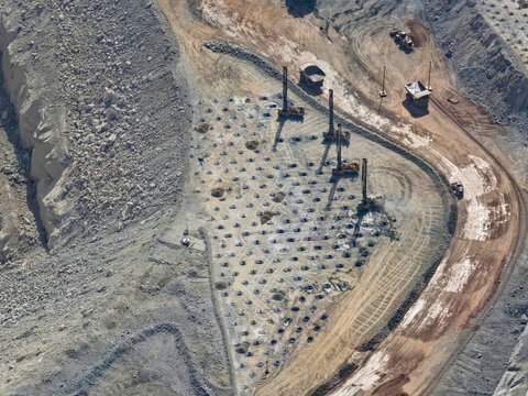 Panoramic view of a drilling and blasting platform with heavy machinery in an open-pit mine