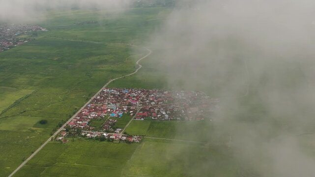 Tea plantations through the clouds view from above. Tea estate landscape. Kayu Aro, Sumatra, Indonesia.