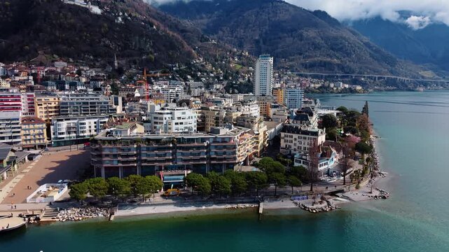 Aerial: Montreux waterfront, Market Place and cityscape during the day in Canton of Vaud, Switzerland, pull out drone shot