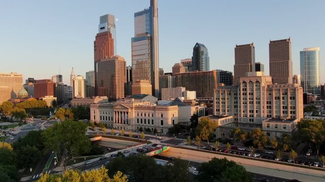 Stunning aerial panorama of Philadelphia city skyline at sunset, showcasing urban architecture, busy streets, and historical buildings under a clear sky with moon