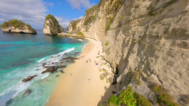 Cinematic FPV drone flight over Diamond Beach in Nusa Penida, Bali, Indonesia with turquoise ocean, cliffs and palm trees. Iconic tropical coastline and popular travel destination in Southeast Asia.