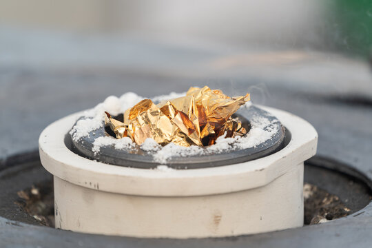 Gold leaf melting in a crucible during a refining process showing intense heat and transformation of precious metal.