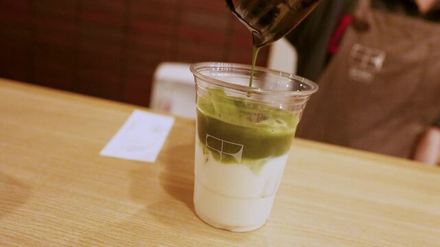 Pouring Fresh Matcha Green Tea Over Milk and Ice in Osaka