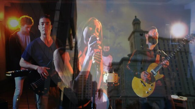 Female vocalist raising mic during song crescendo, band ramping on yellow guitar, tower over band