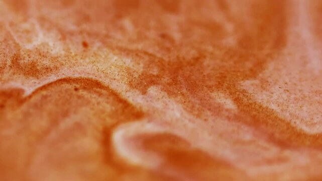 Ink stream. Wet texture. Defocused orange color grain paint in water chemical flow spreading on abstract art creative wet background.