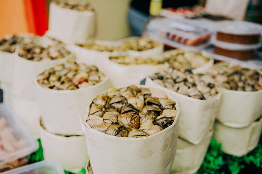 Traditional Filipino Suman in Banana Leaves, Local Dairy Delicacy in White Paper Containers, Philippines Street Food Market