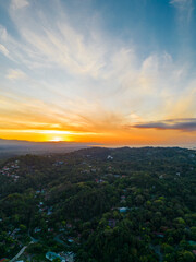 Fototapeta premium Panoramic aerial vertical shot of the mountainous area full of vegetation with a sunrise in Quepos in the Puntarenas Province of Costa Rica