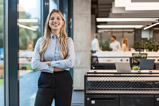 Confident stylish european woman standing at workplace, executive leader manager smiling.