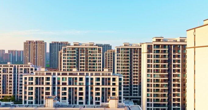 High angle view of modern residential apartment buildings under clear blue sky. High density urban housing complex representing modern real estate development and city life.