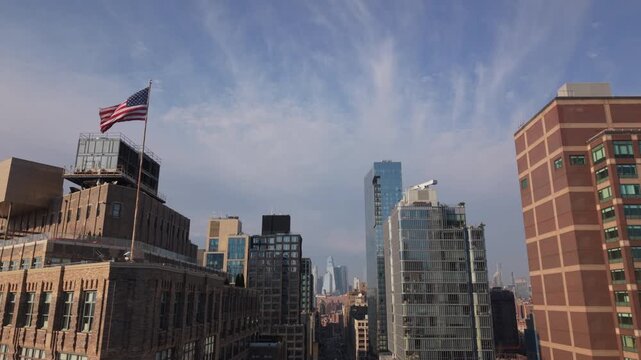 rising and tilting down shot of American flag at corner of 6th Ave. and Canal St. in NYC