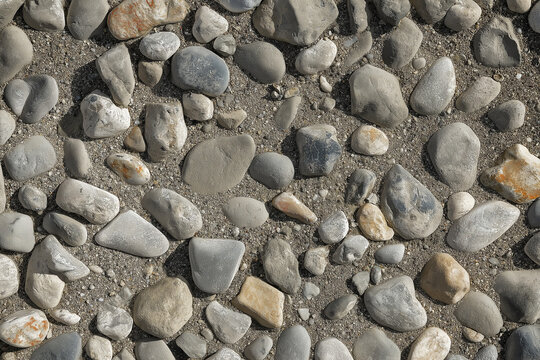 An aerial view of a large, stony surface ground texture. Image is ready to be tiled to create a much larger image or higher resolution background of a detailed sandy pebble aggregate floor