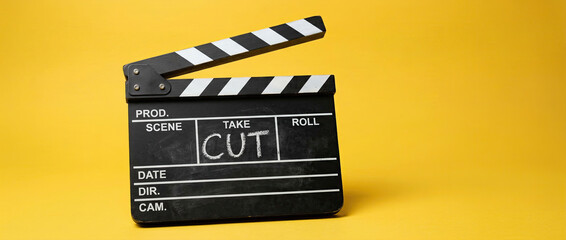 Naklejka premium Movie Clapperboard with Cut Text on Bright Yellow Background