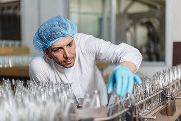 Glass bottle and food packaging manufacturing plant worker Product Visual Inspection in plant line.