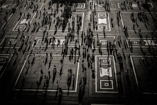 Long Shadows of People and Geometric Patterns in Piazza del Duomo Seen from Above in Milan, Italy
