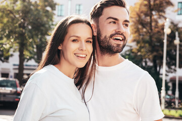 Fototapeta premium Smiling beautiful woman and her handsome boyfriend. Woman in casual summer jeans clothes. Happy cheerful family. Female having fun. Sexy couple posing in the street at sunny day