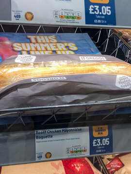 London, United Kingdom, 13 July 2023, Greggs baguette sits behind price sign inside the shop in London. Product branding and sandwich information are clearly printed on display.