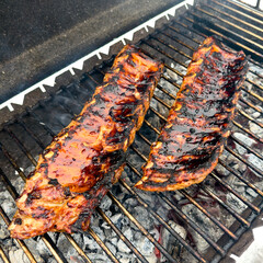 Ribs on a grill with a lot of smoke coming off of them © schankz