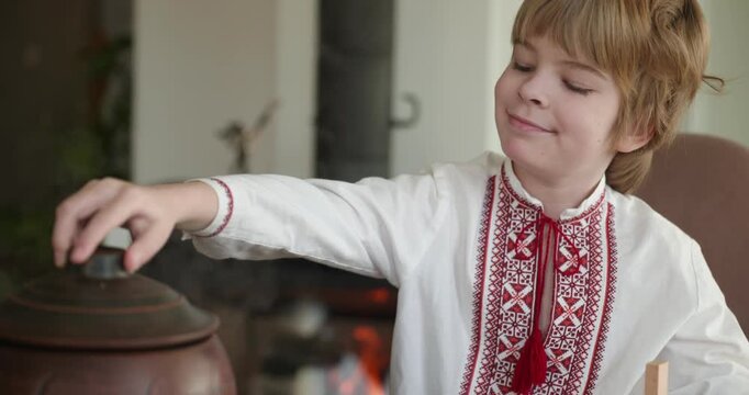 Kid Boy Waiting For Dinner. Man Serving Dishes on Table Family in Ukrainian Traditional Attire Childhood. 4K 10-bit
