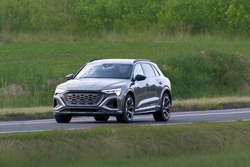 Fototapeta premium Contemporary electric SUV motion on rural street