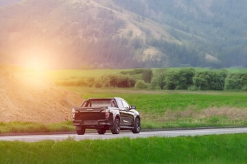 Countryside road with a black pickup truck at dawn © AlexGo