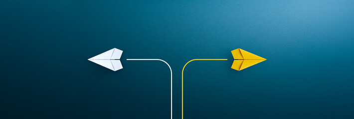 Two paper planes flying in opposite directions on blue background, concept of decision making and...