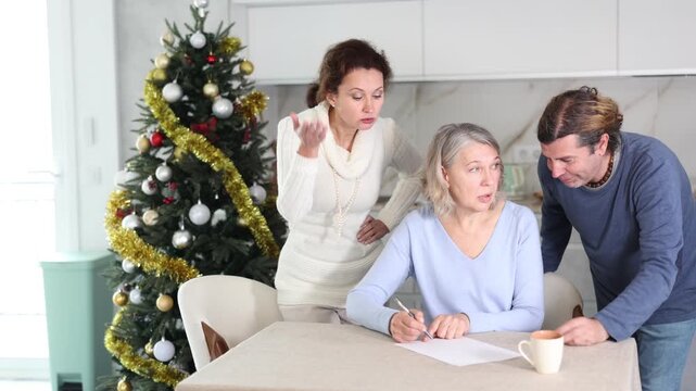 On Christmas Eve man and woman help elderly mother make will and fill out document correctly. Family advice, help and support