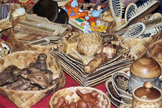 Russian folk crafts market scene, woven baskets and carved wooden items on display table, traditional artistry