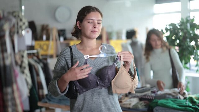 Attractive female customer choose new bra in big boutique