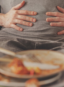 Woman with bloating and stomach pain after eating