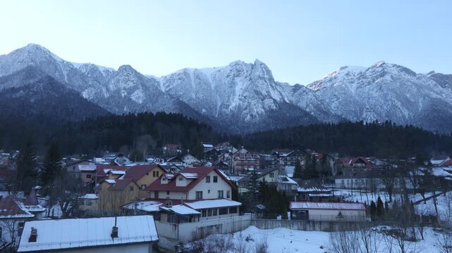 Beautiful scenic view of the Bucegi Mountains in Romania, filmed from a mountain cabin overlooking a peaceful rural village with traditional houses.