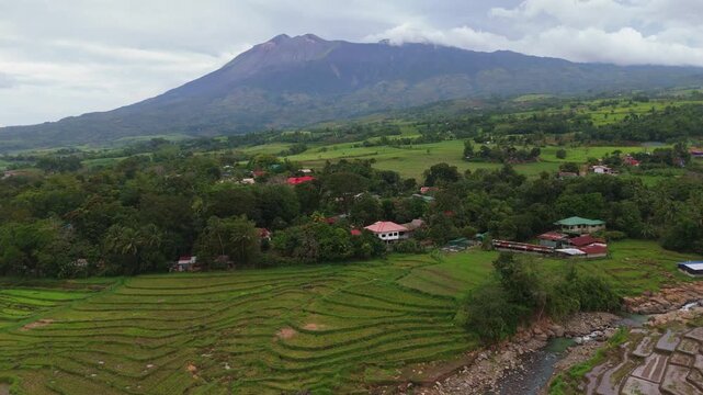 Aerial view of Mount Canlaon volcano towering over lush green agricultural fields and rural landscapes in Canlaon City, Negros Oriental, Philippines. Stunning volcanic scenery