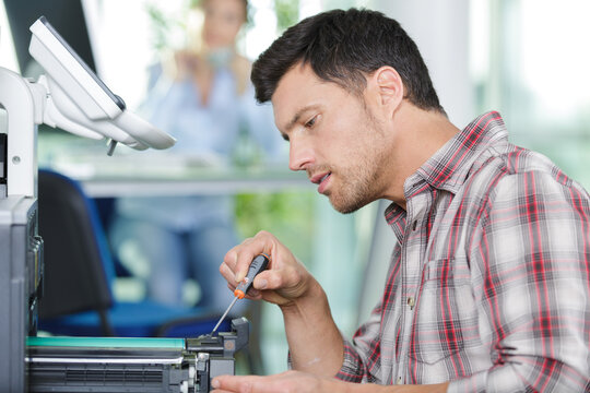 hardware repairman repairing broken printer fax machine