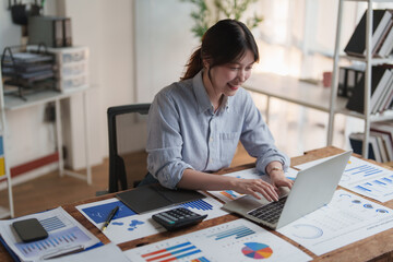 Fototapeta premium Happy young woman working on financial data analysis