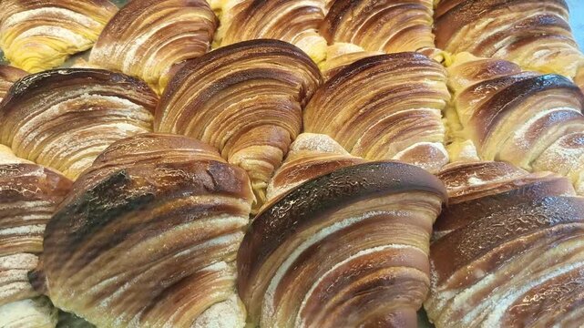 Vegan artisan croissants aligned showing golden texture and handcrafted production